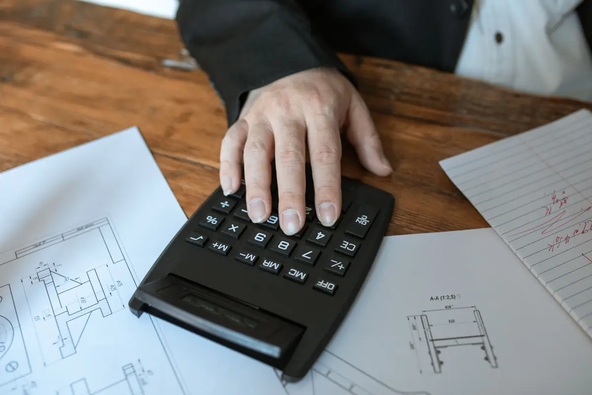 Devis de travaux, plans et calculatrice sur un bureau